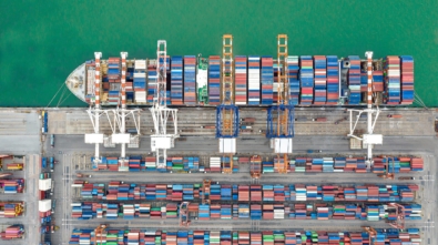 Aerial view Container ships at industrial ports in the business of import, export, logistics and international maritime transport, loading of containers on cargo ships with cranes,
Transportation of goods by container trucks to customers.