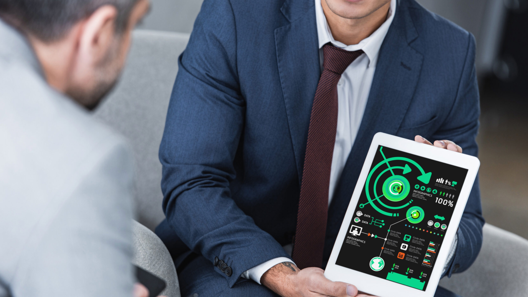 cropped shot of young businessman showing digital tablet with business charts to colleague
