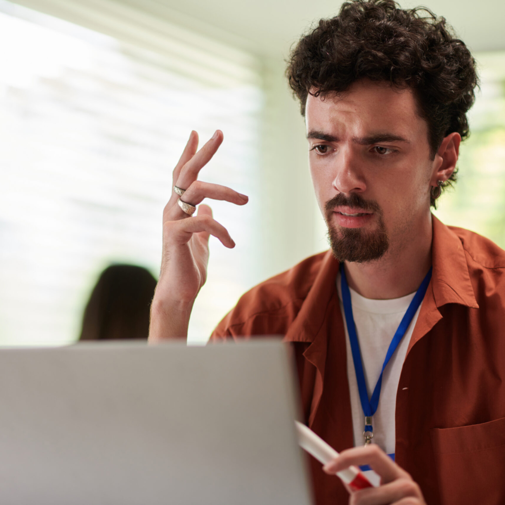 Emotional devops engineer talking to colleagues at online meeting