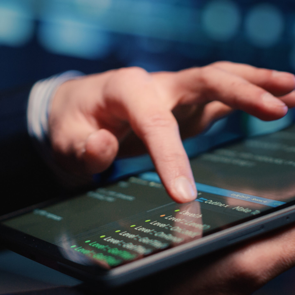 Male system administrator inspecting big data on tablet, working in modern data center. Infrastructure specialist inspecting server rack systems, artificial intelligence. Handheld shot. Close up.
